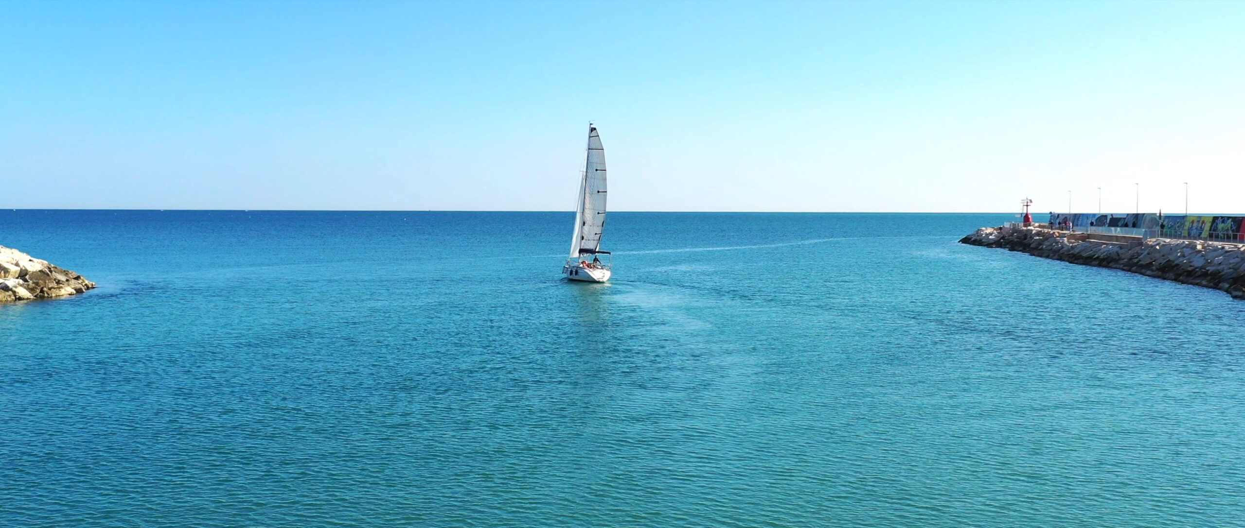 Barca a vela in uscita dal porto